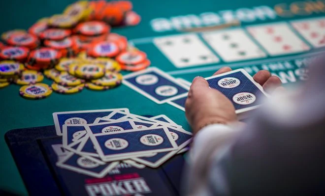 what is a 3 bet in poker - poker table and hand with game card
